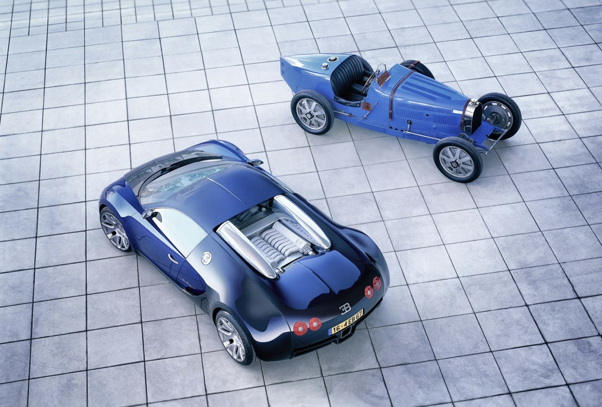 Two blue Bugatti cars from different eras, photographed from above